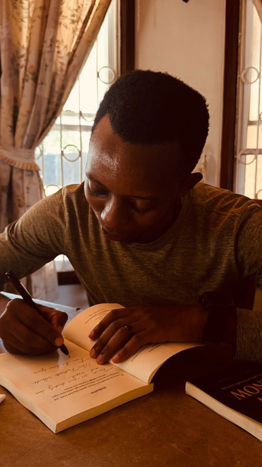 Signing a copy at the table.