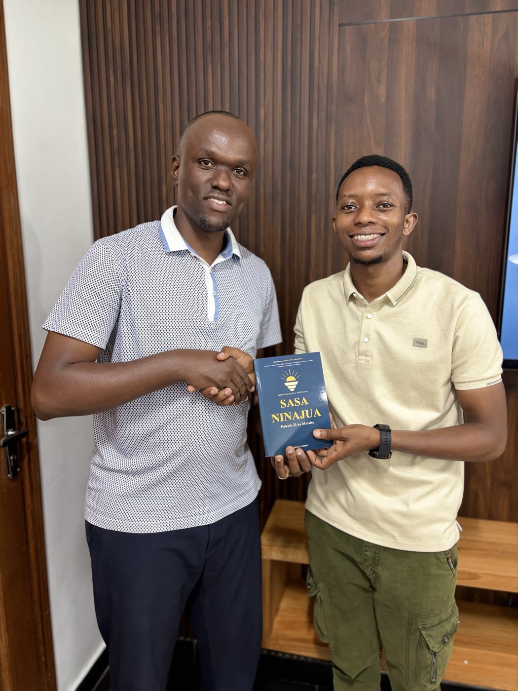 Handing over a copy of Sasa Ninajua.